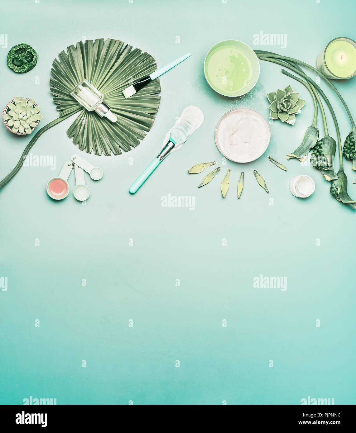 Natural cosmetic background. Tools and accessories for home facial skin care with flowers and green tropical leaves, top view, flat lay. Serum,  face  Stock Photo