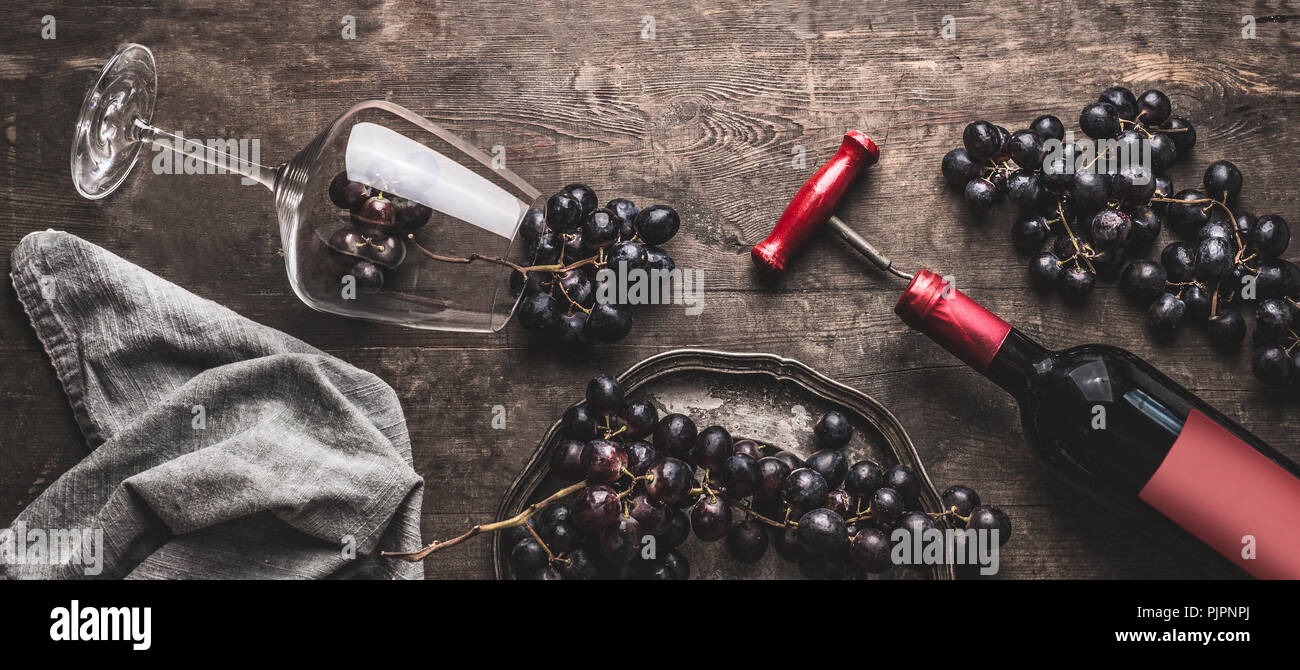 Red wine still life with bottle and vintage corkscrew, glass and grapes ...
