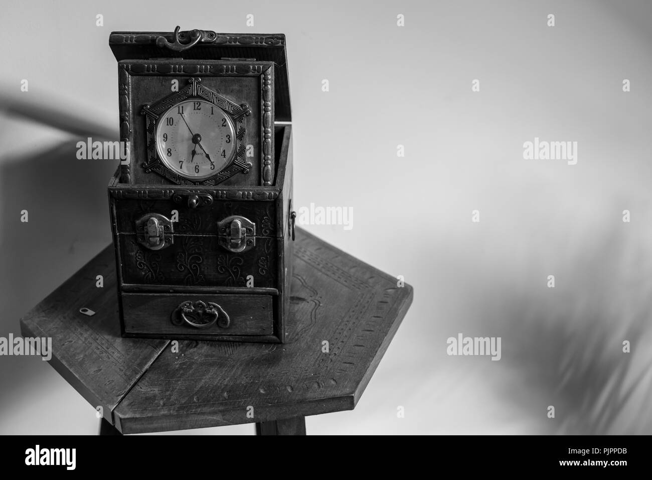Antique clock sitting on an vintage table Stock Photo