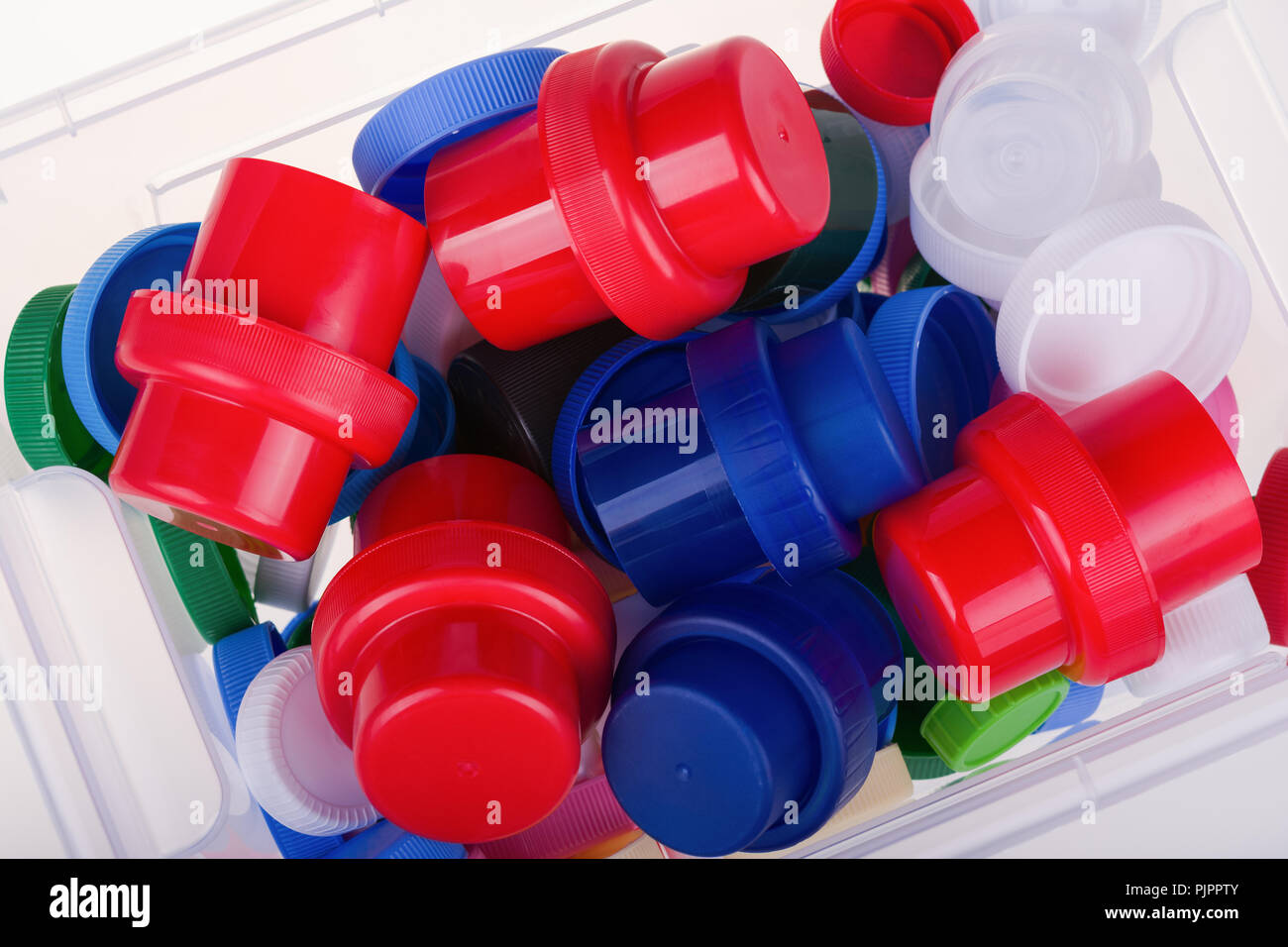Colorful plastic lids in a box on white background Stock Photo Alamy