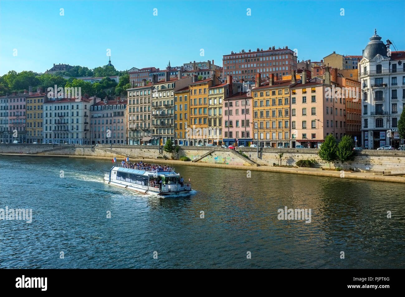 Tourist electric boat passing the Quai Saint-Vincent on the Saone river in Lyon France. Stock Photo