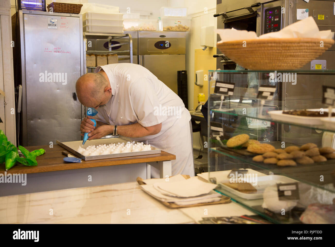 Expert baker craftsman making meringues inside the Little Bakehouse