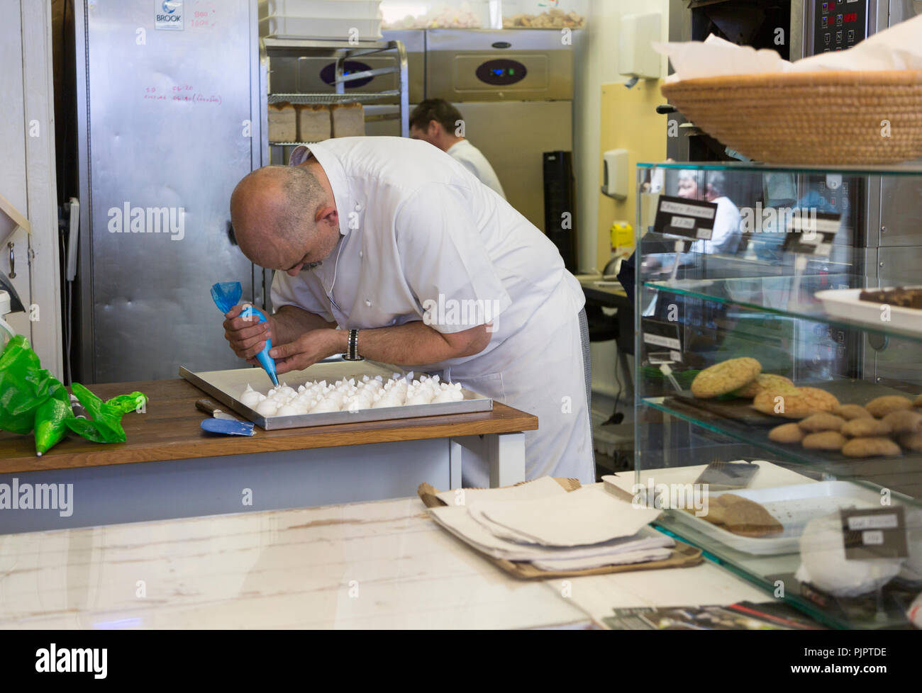 Expert baker craftsman making meringues inside the Little Bakehouse