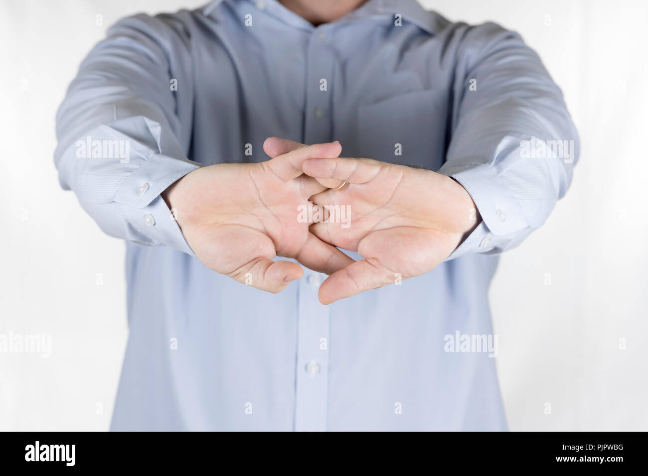 Man cracking the knuckles of his hands and fingers (knucklecracking or knuckle joints Stock
