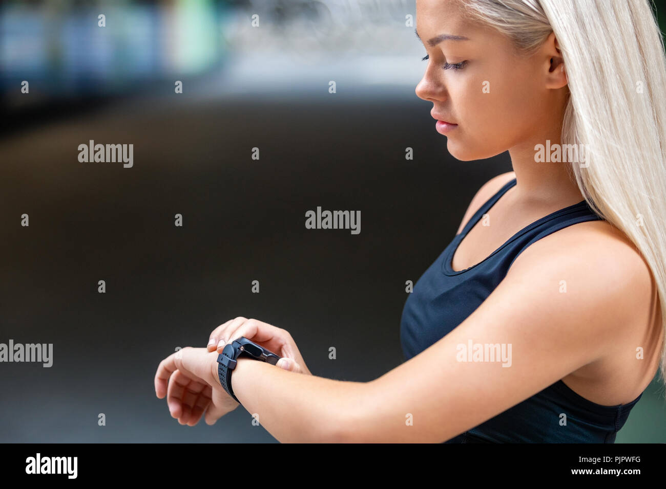 Female Runner Checking Smartwatch After Workout On Road Stock Photo