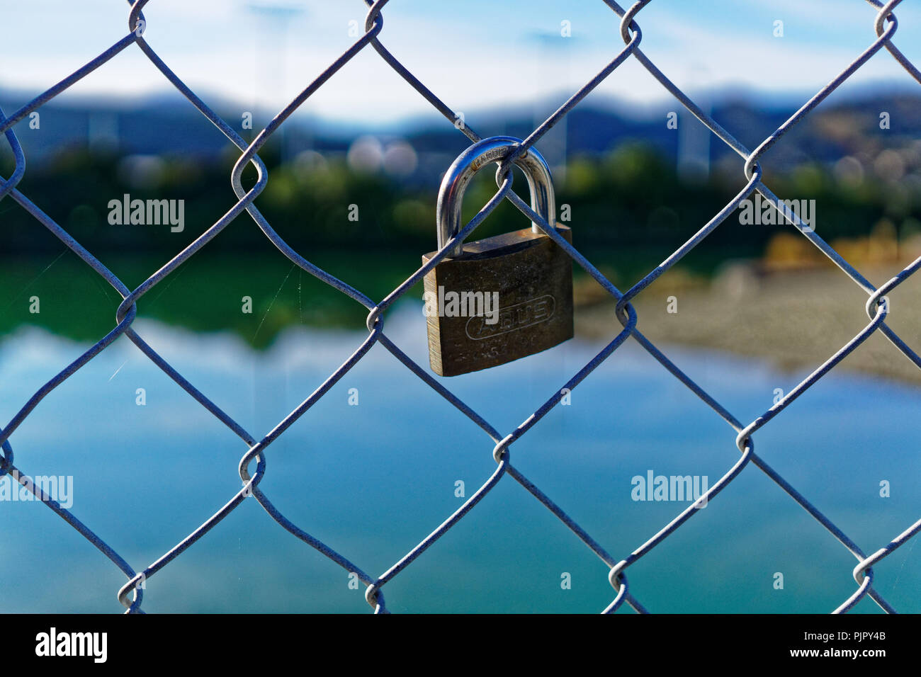 Lock locked onto a chain link fence Stock Photo Alamy