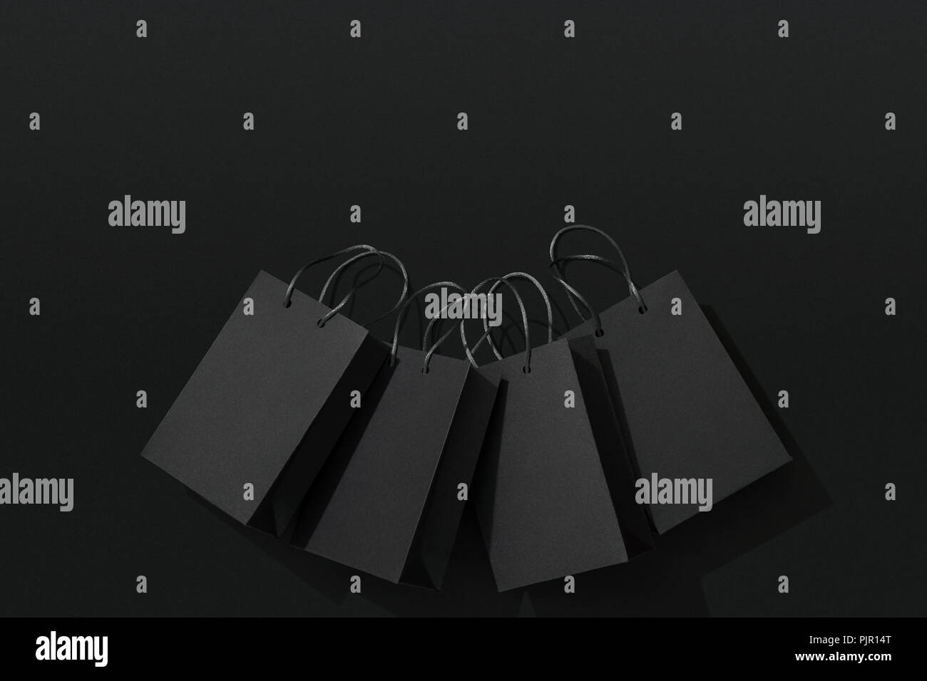 Black shopping bags on black background Stock Photo