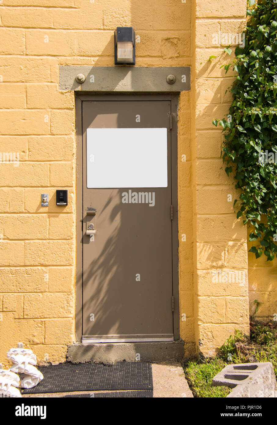 Beige Metal Door In Yellow Cinder Block Wall With White Blank Sign Blank Copy Space Stock Photo Alamy