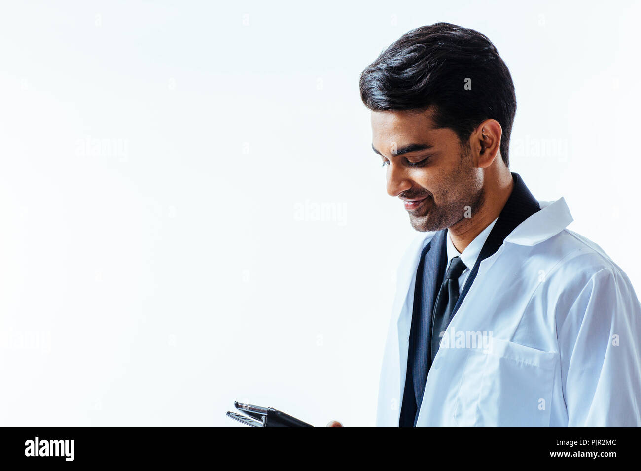 Profile portrait of a man in business suit and lab coat holding a folder, isolated on white studio background Stock Photo