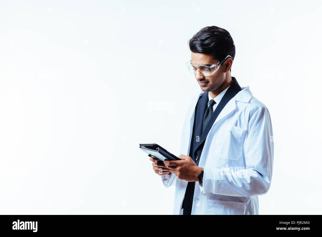 Portrait of a man in business suit, lab coat and protective glasses