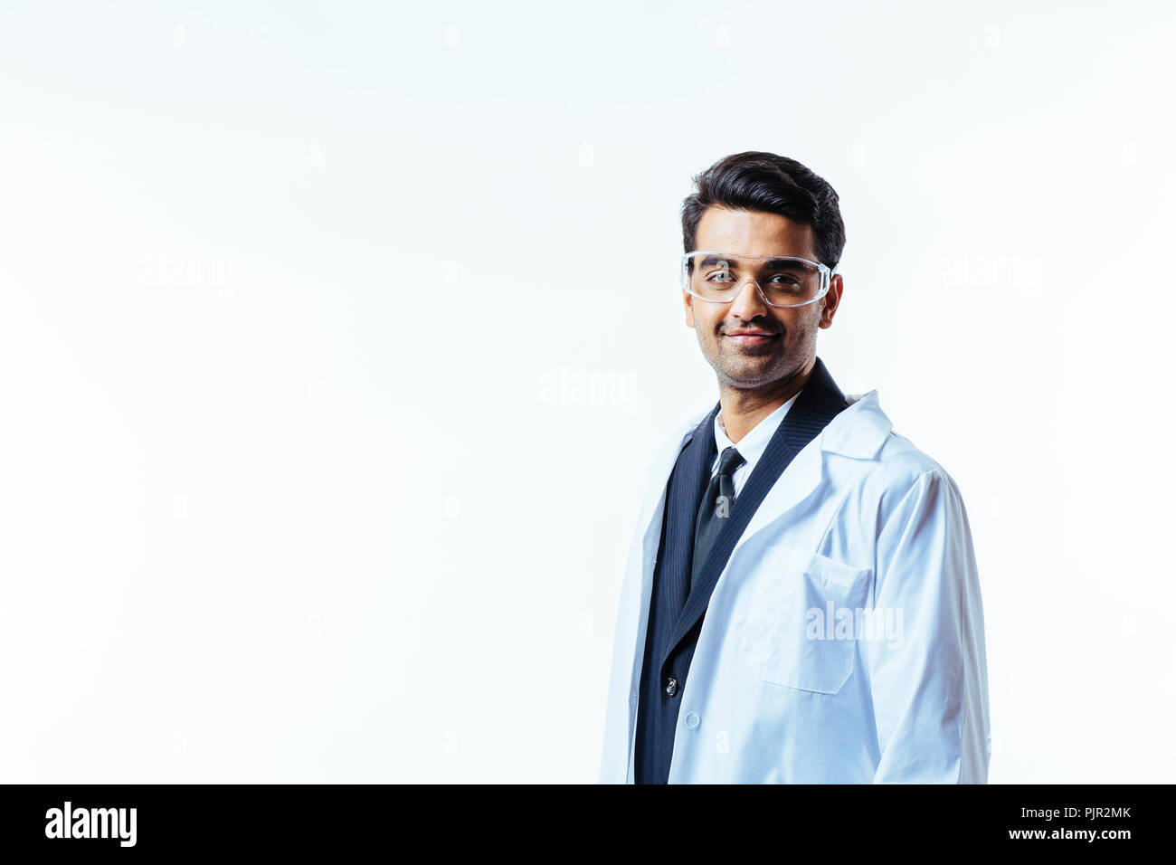 Portrait of a man in business suit, lab coat and protective glasses