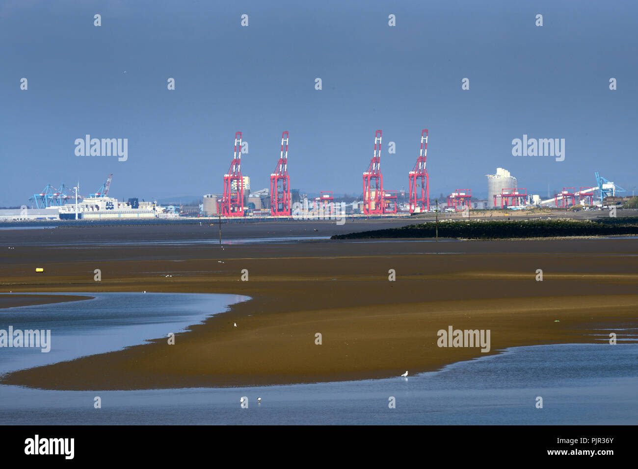 View across the mouth of the river Mersey from Leasowe towards Liverpool docks and Container Port. Stock Photo