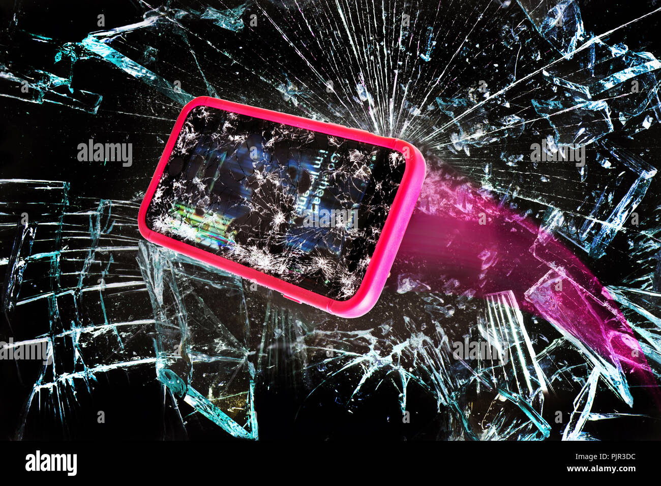 Broken cell phone going through shards of glass. Stock Photo