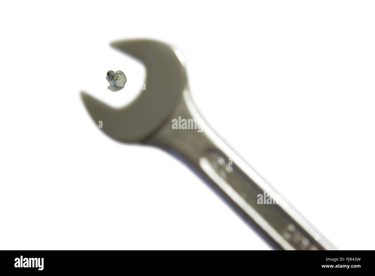 A little screw and a far too big wrench Stock Photo Alamy
