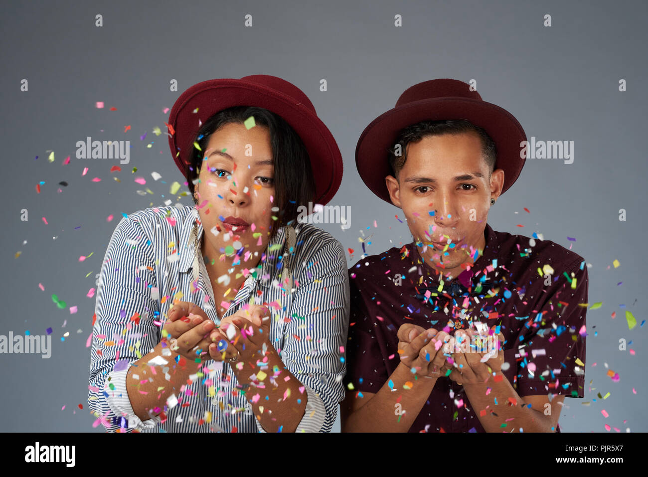 Fun moment of happy young people blowing colorful confetti Stock Photo