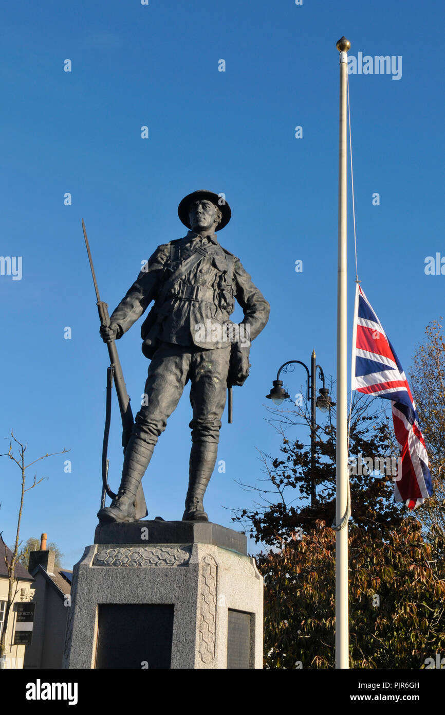 Memorial to soldiers killed during World War 1 beside a flagpole flying the Union Jack flag at half mast. Stock Photo