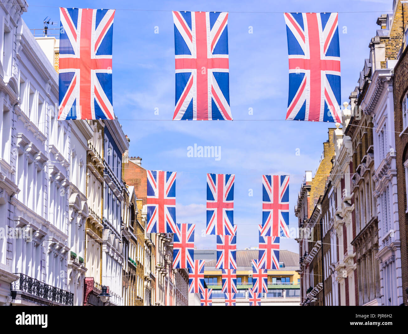 Many Union Flags Union Jacks flying above a street in London. Stock Photo