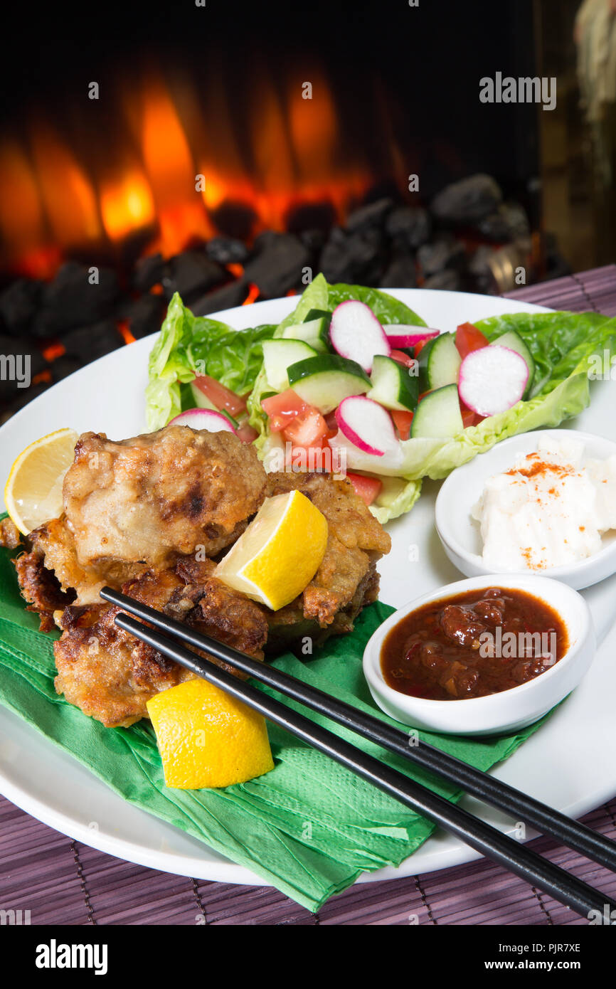 A plated meal of Chicken Karaage with red chili bean dip and Paprika yogurt served with a fresh mixed salad Stock Photo