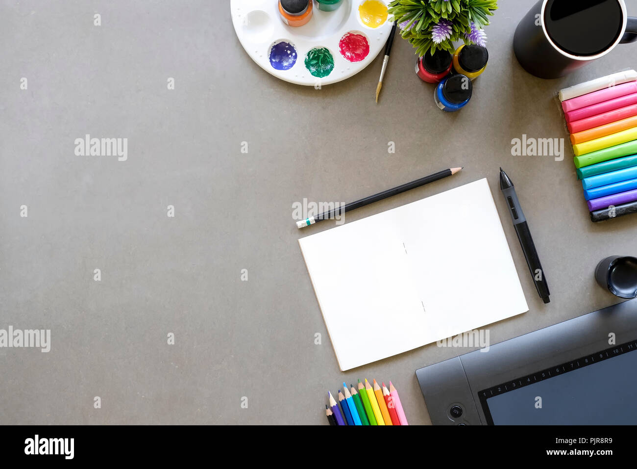 Artist workspace top view a graphic design table with digital mouse pen,sketch  book , colour pencil, cup of coffee and water cooler for a copy space Stock  Photo - Alamy