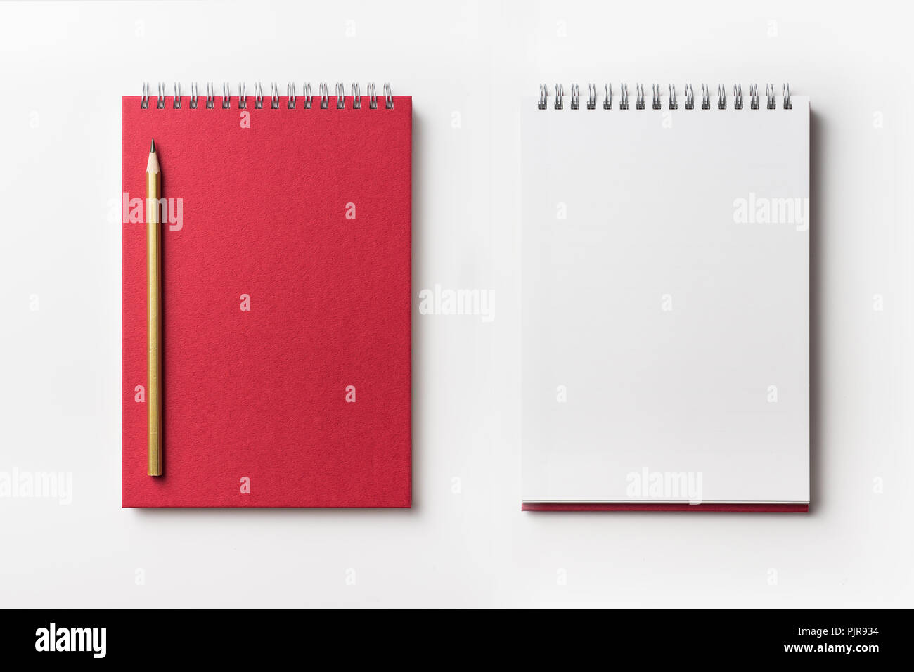Design concept - Top view of red spiral notebook and color pencil collection isolated on white background for mockup Stock Photo