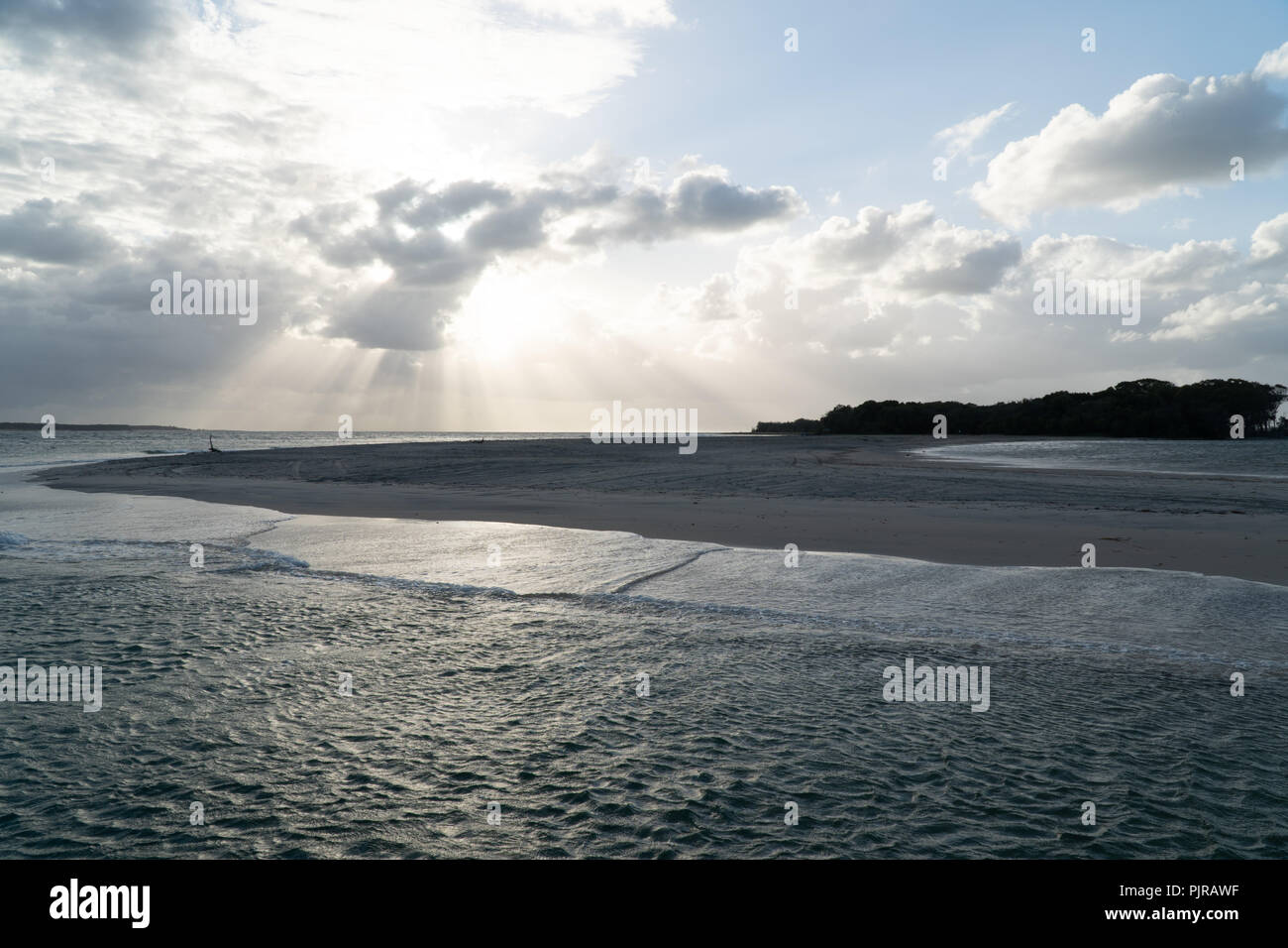 Sunrays through the clouds at the beach at Fraser Island, Australia Stock Photo