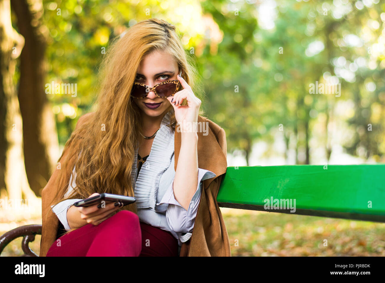 Woman on a park bench hi-res stock photography and images - Alamy