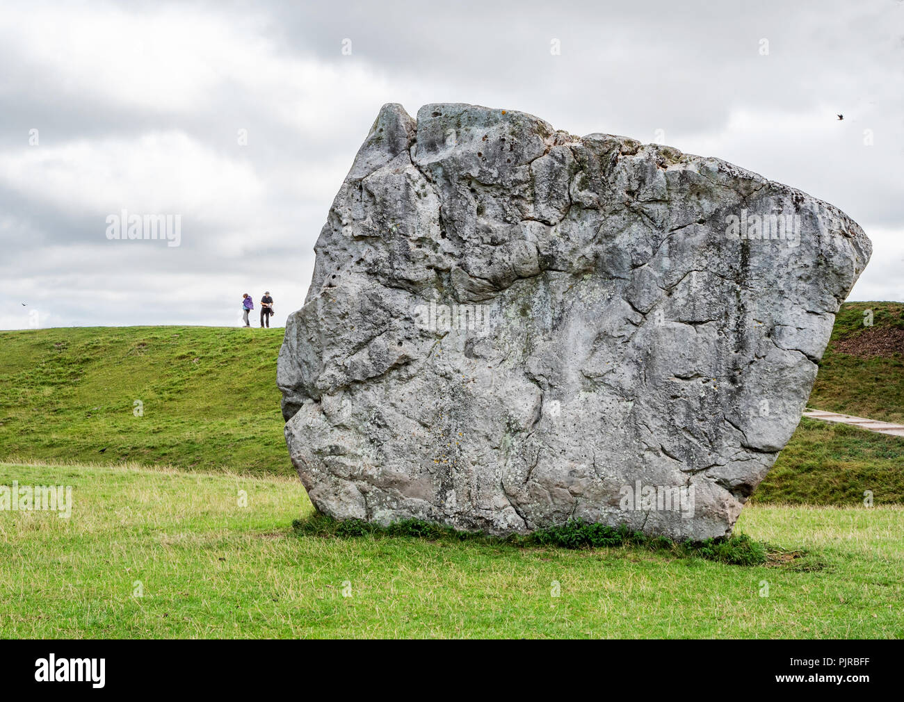Gigantic sarsen stones at Avebury neolithic henge in Wiltshire UK which contains a village pub and three stone circles within its circumference Stock Photo