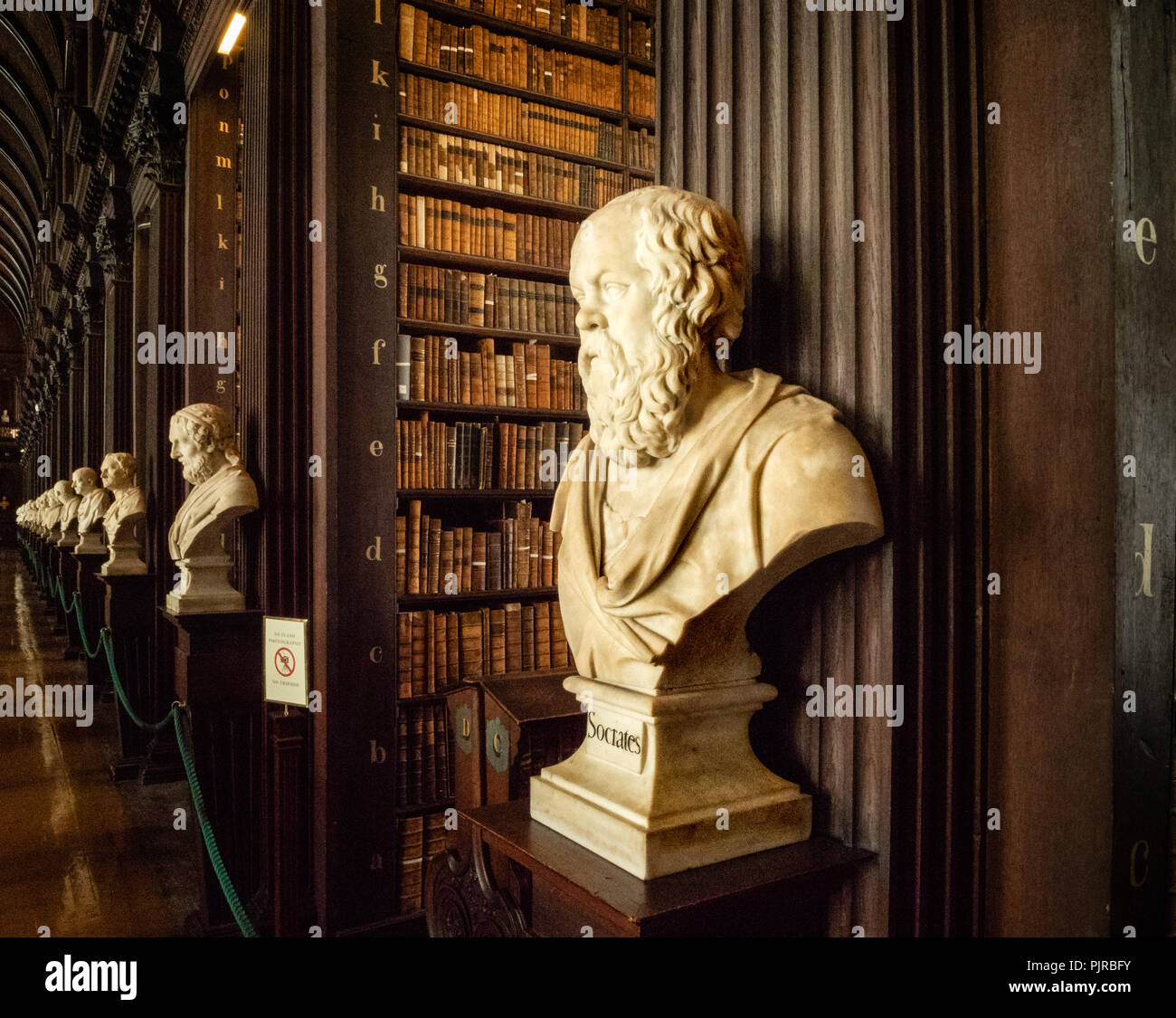 Magnificent oak panelled interior of Trinity College Library in Dublin Ireland with busts of historical philosophers headed by Socrates Stock Photo