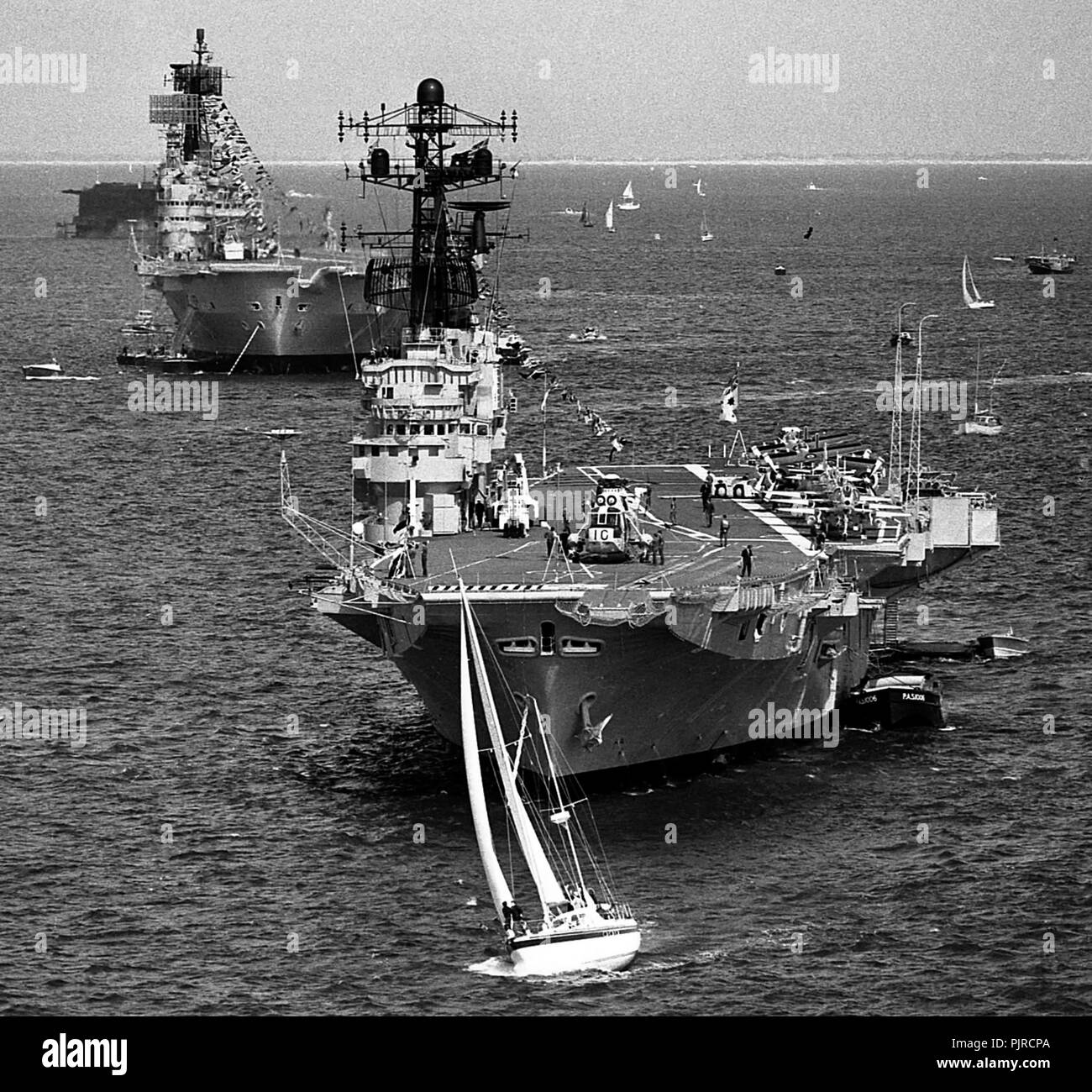 AJAXNETPHOTO. 28TH JUNE, 1977. PORTSMOUTH, ENLAND. - LINE ASTERN -  THE AIRCRAFT CARRIERS HMAS MELBOURNE AND HMS ARK ROYAL AT THE SILVER JUBILEE FLEET REVIEW.  PHOTO:JONATHAN EASTLAND/AJAX.  REF:HDD ()NA MELBOURNE 1977 11. Stock Photo