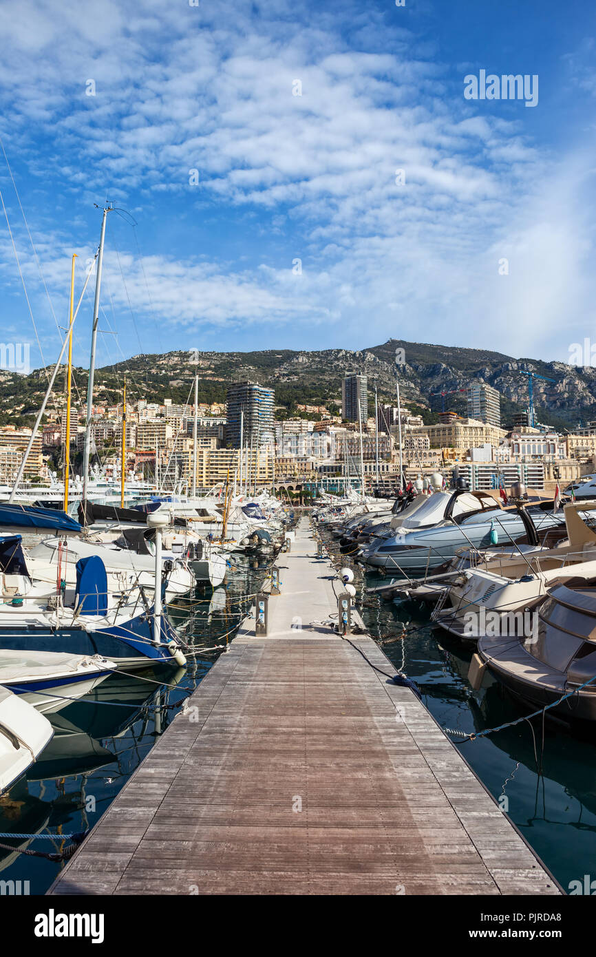 Yachts and sailing boats in Monaco principality, view from pier in Port Hercule to Monte Carlo at Mediterranean Sea Stock Photo