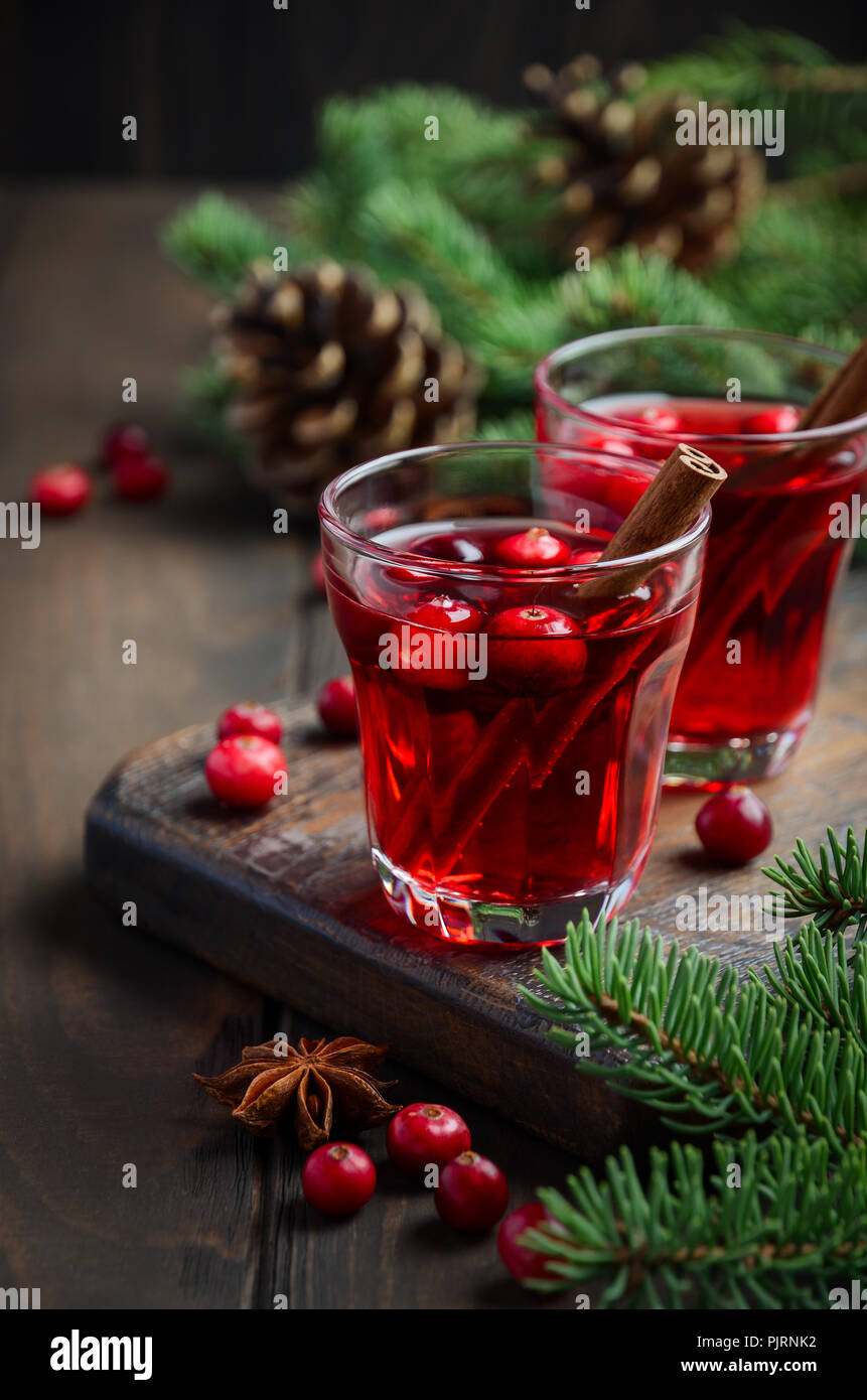 Cranberry Drink on Wooden Background Decorated with Fir Branches, Spices and Fresh Berries Stock Photo