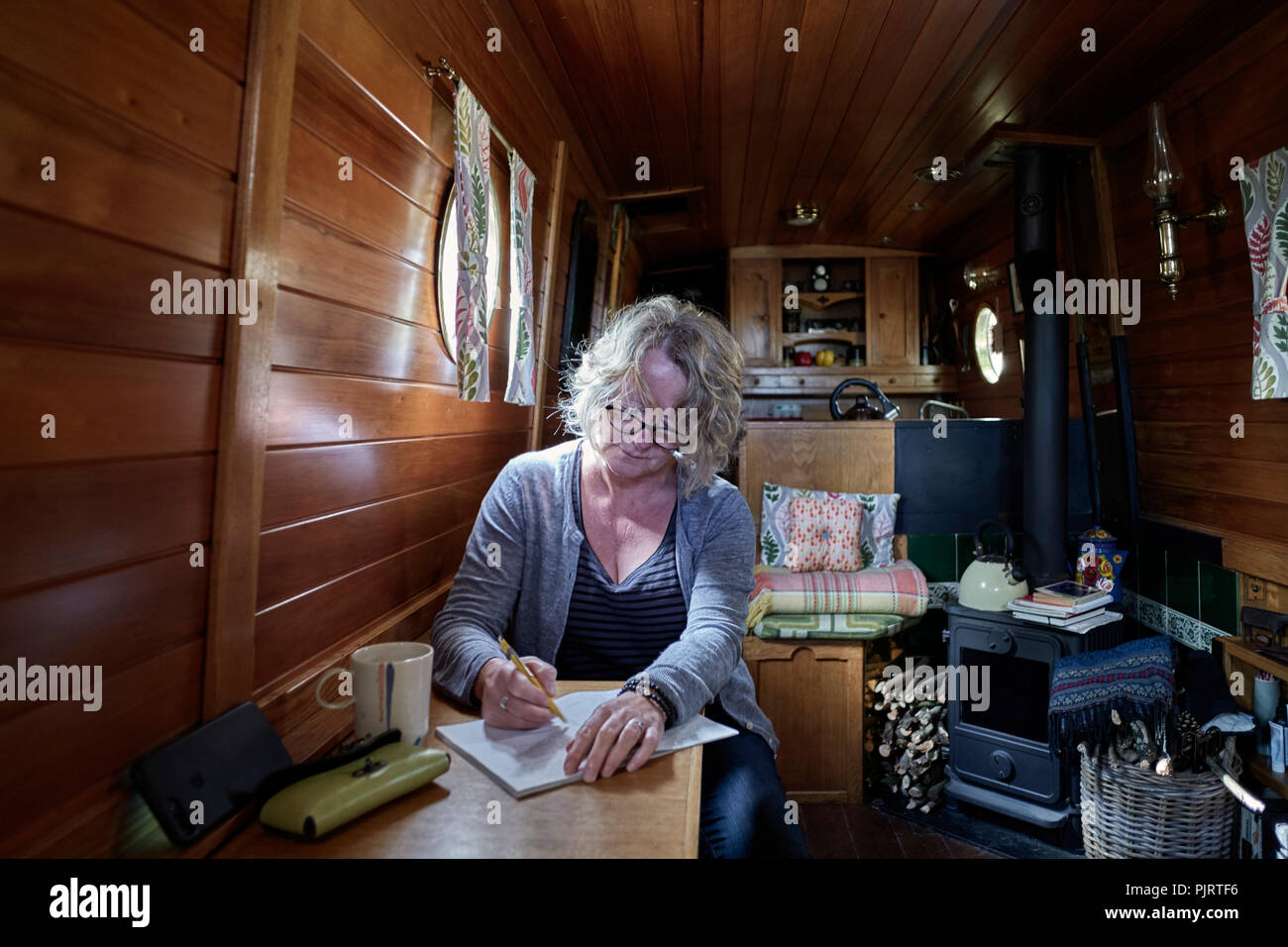 Poet and artist Janet Lees at work in the canal boat William Stock Photo