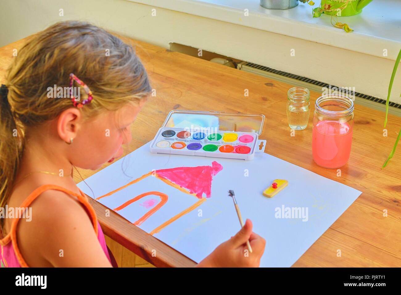 Little girl painting simple picture. Cute girl painting with