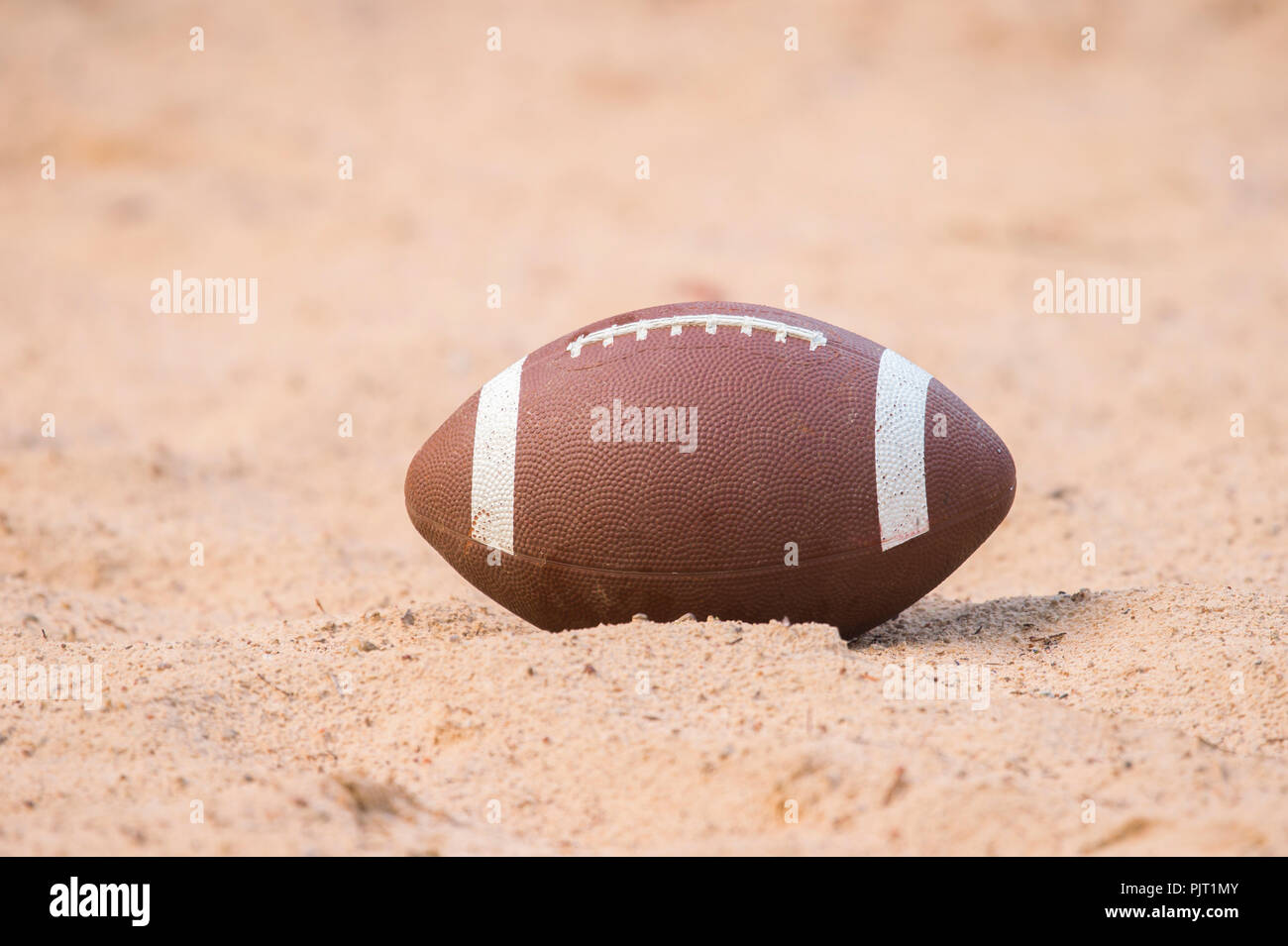 American football in the sand on the beach Stock Photo Alamy