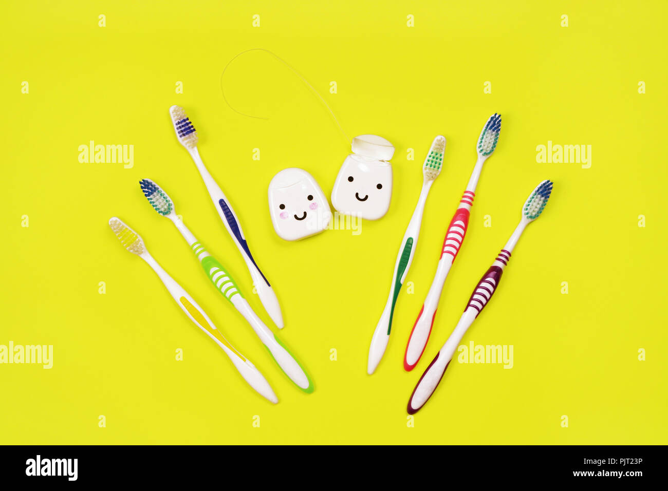Toothbrushes and dental floss on yellow background,top view Stock Photo