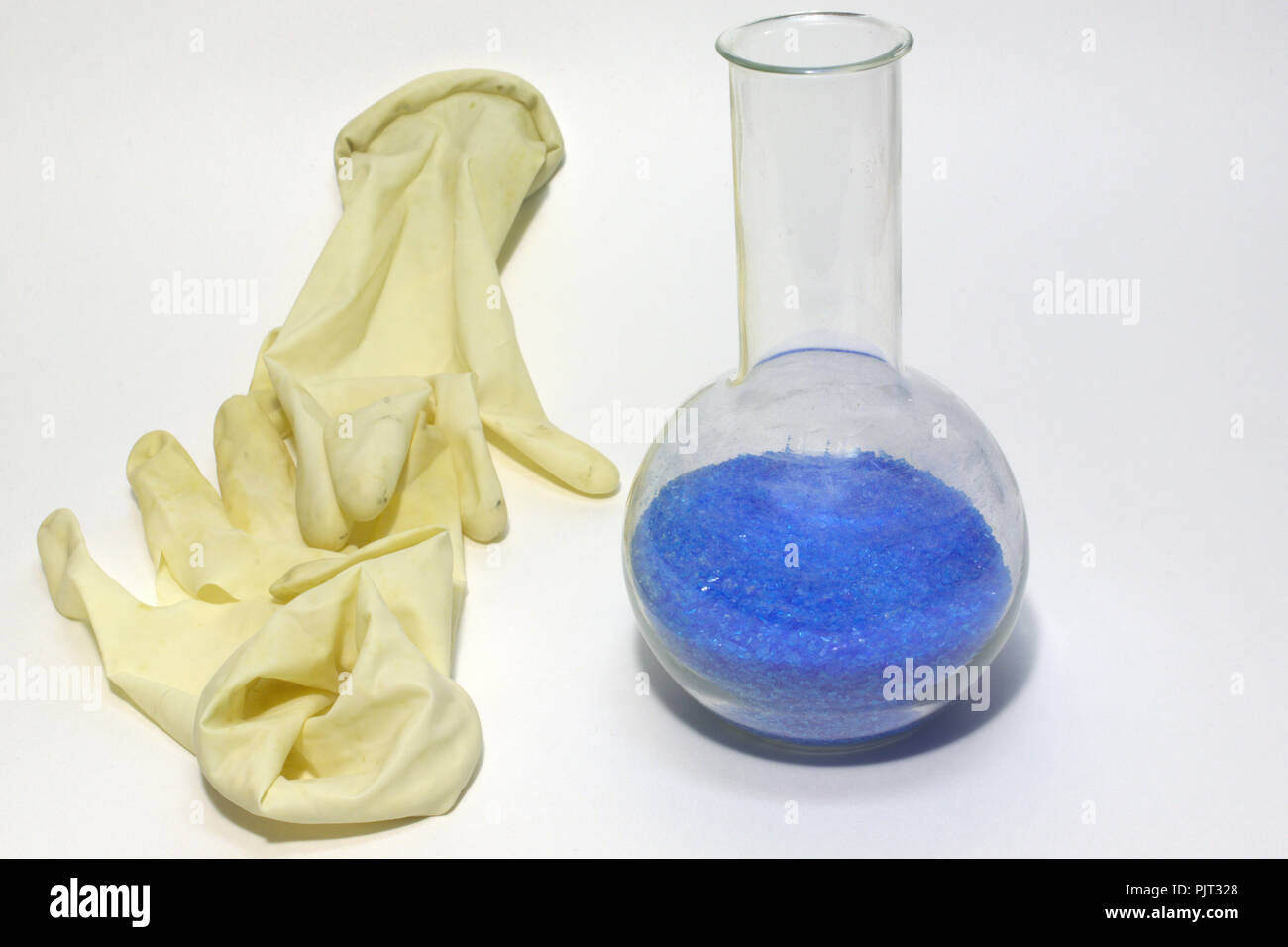 hygiene latex gloves and roundshaped lab flask with crystals of copper