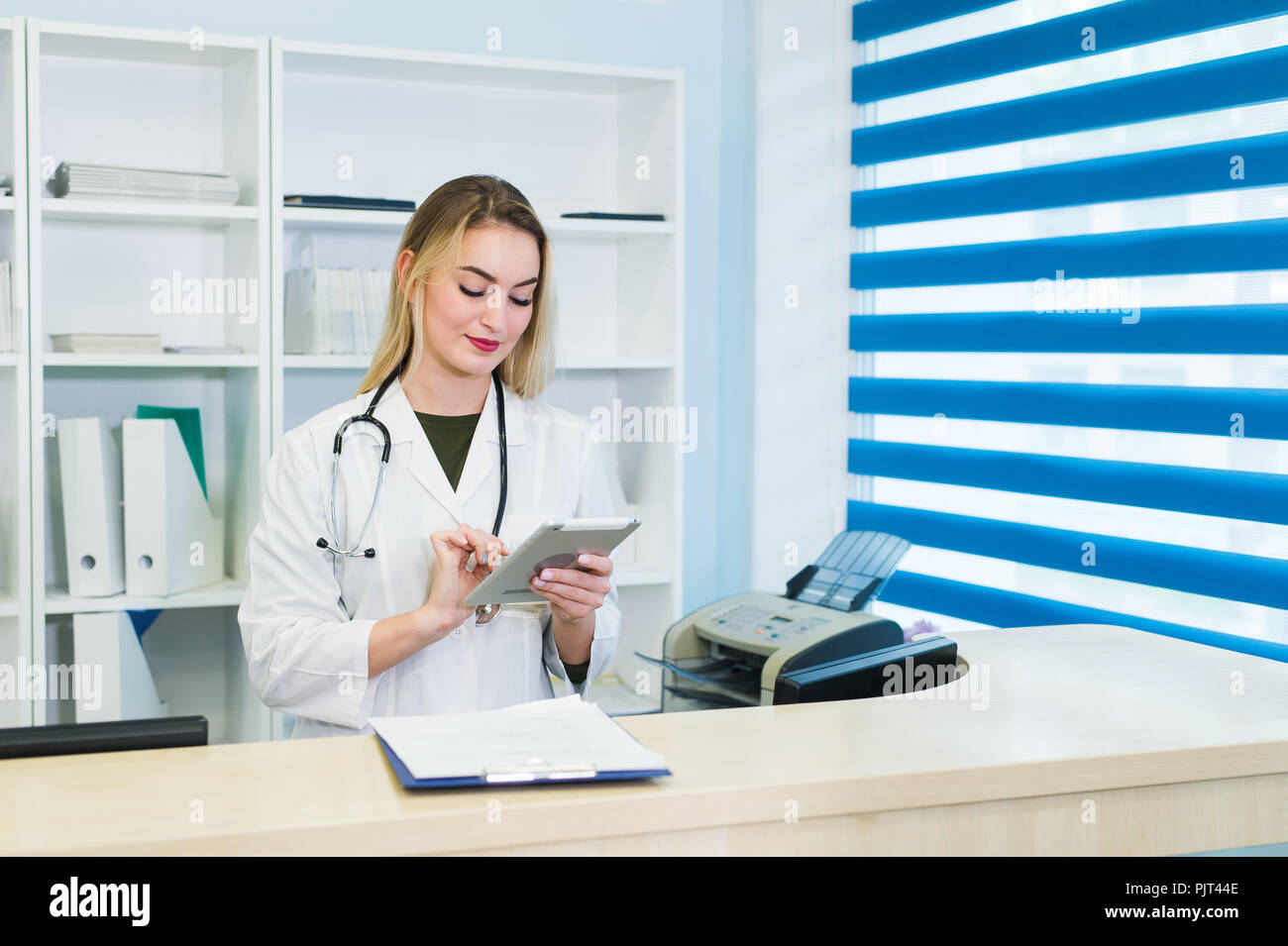Female doctor using tablet at desk in office Stock Photo