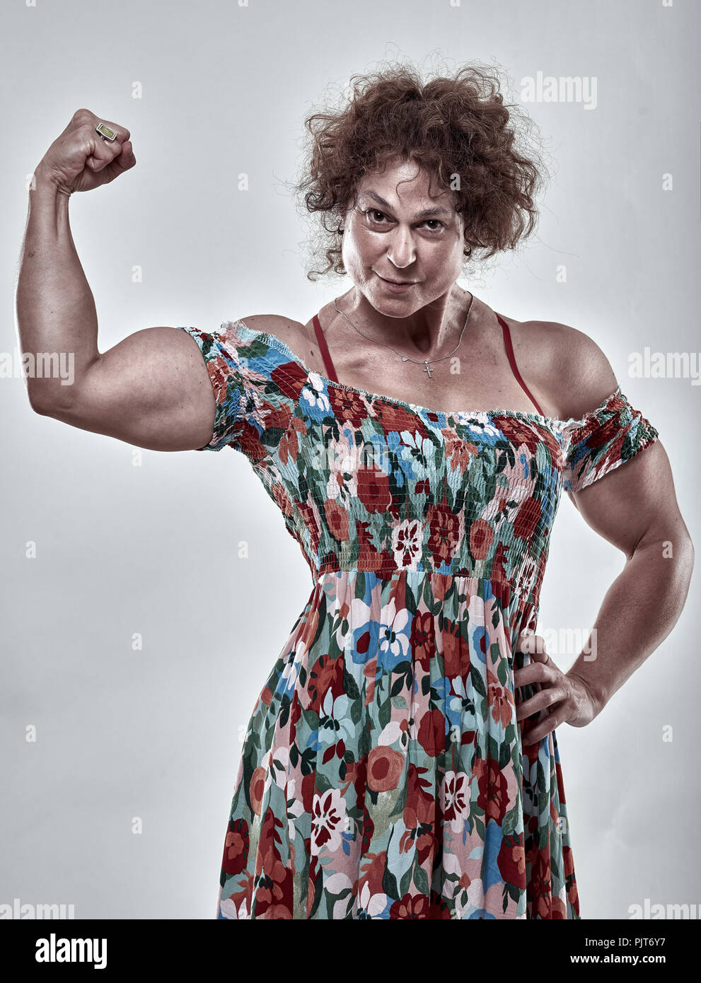 Girls power metaphor with muscular mature woman flexing biceps Stock Photo