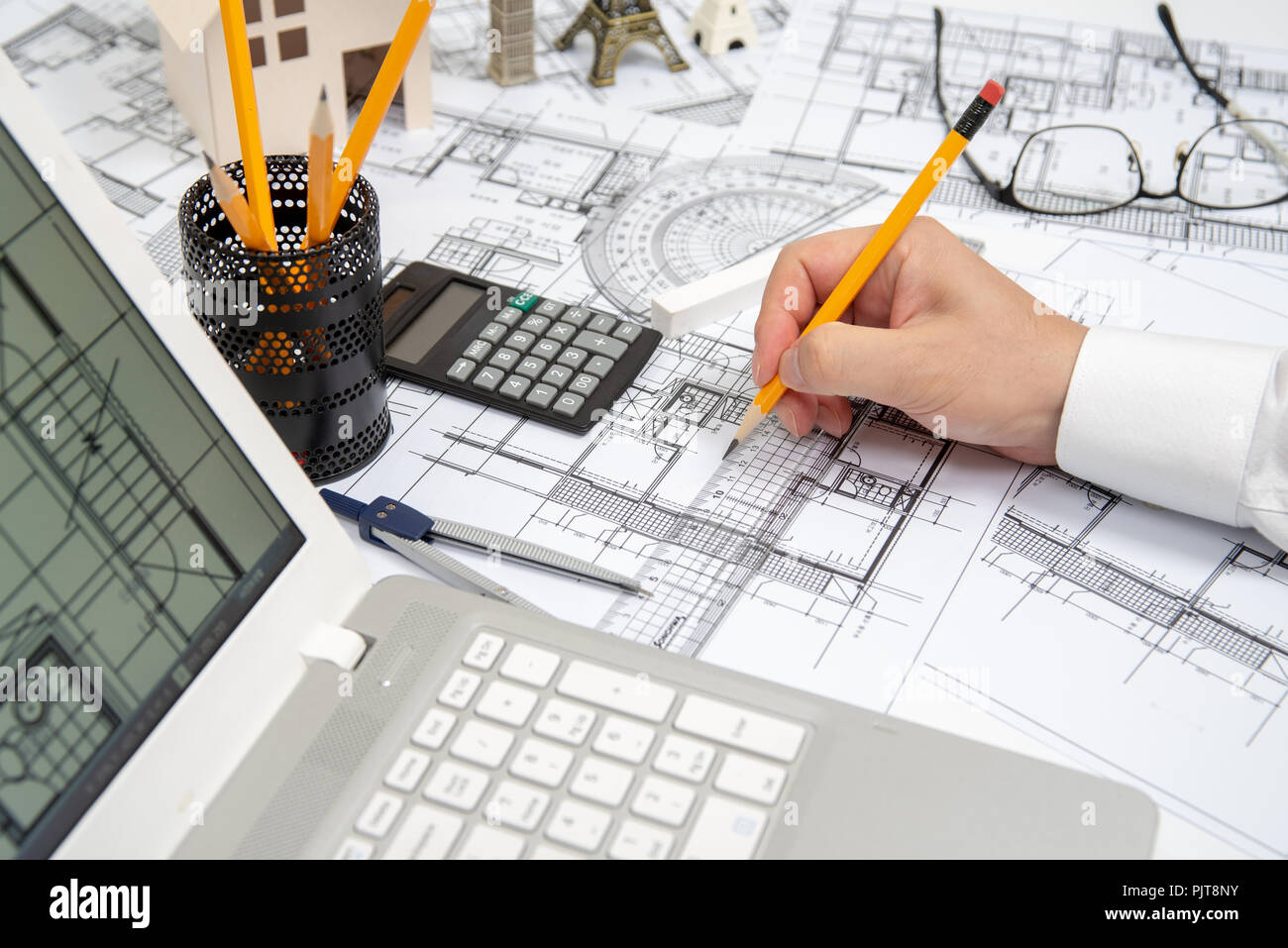 The hand of a male architect drawing a design using a pencil. Stock Photo