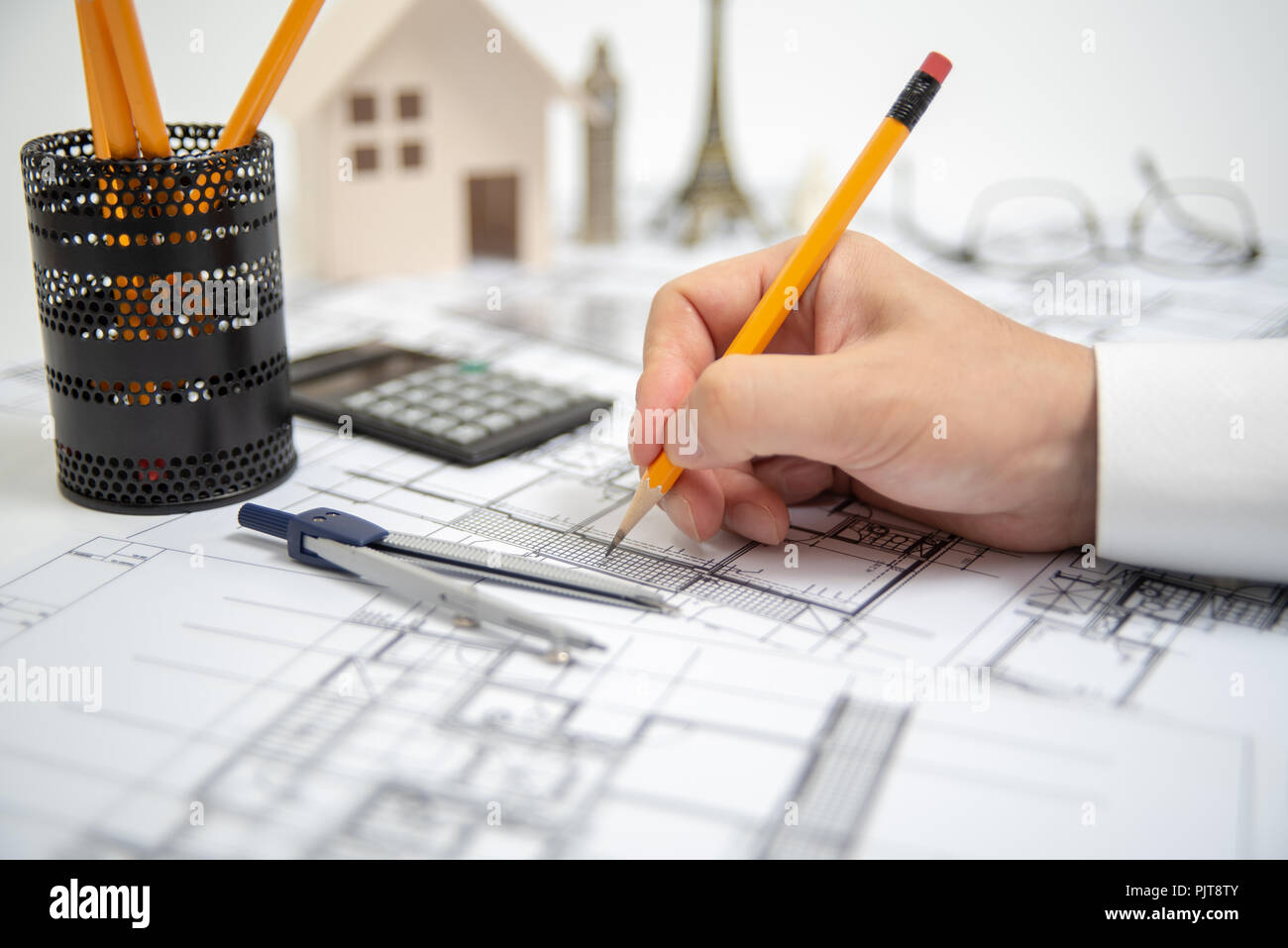 The hand of a male architect drawing a design using a pencil. Stock Photo