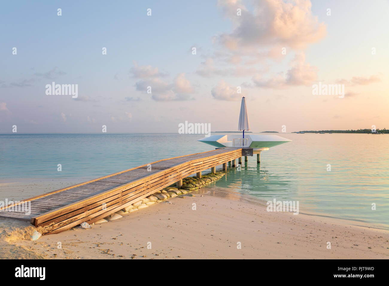 Wooden pier, jetty at tropical island resort in early morning, Maldives ...