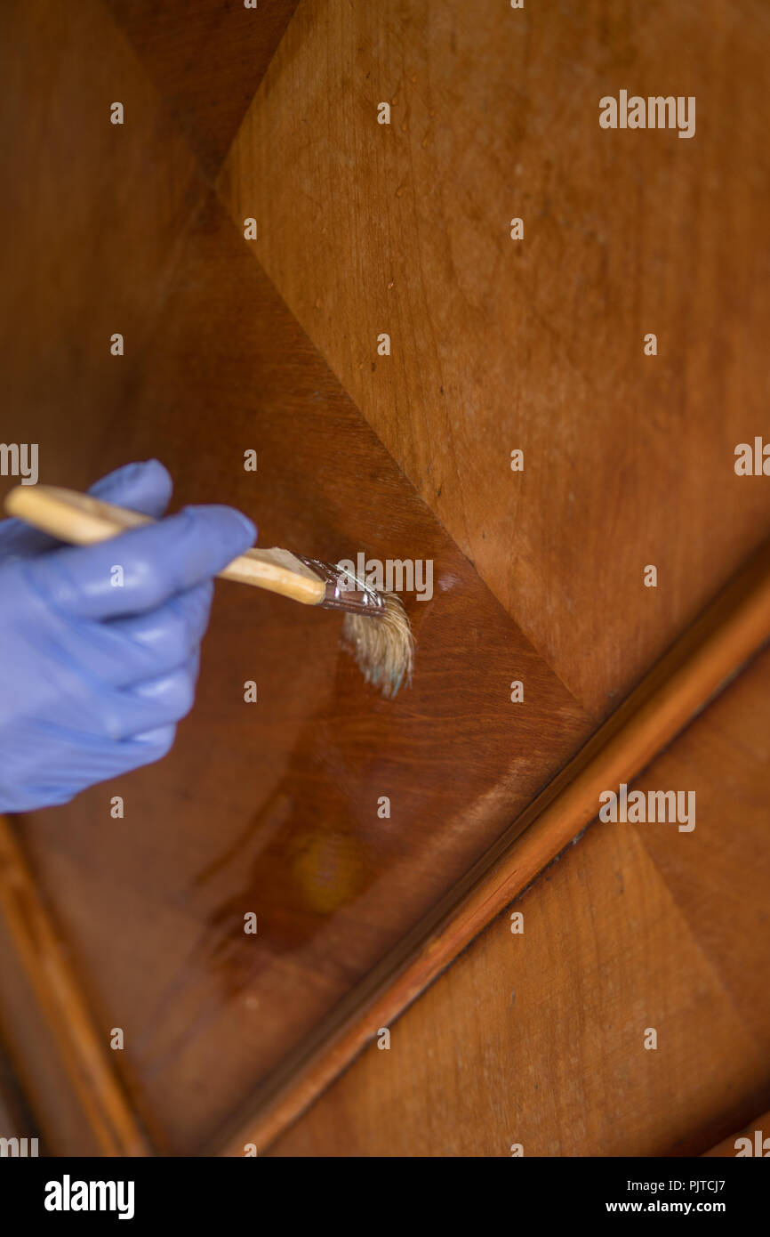 removing wax with a paintbrush as a part of restoration process of old