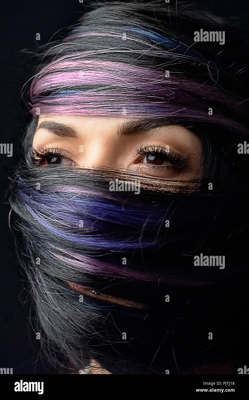 Portrait of a woman's face wrapped in her own hair Stock Photo