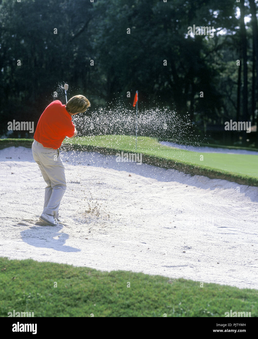 1990 HISTORICAL MALE GOLFER HITS BALL OUT OF SAND TRAP ON TO PUTTING