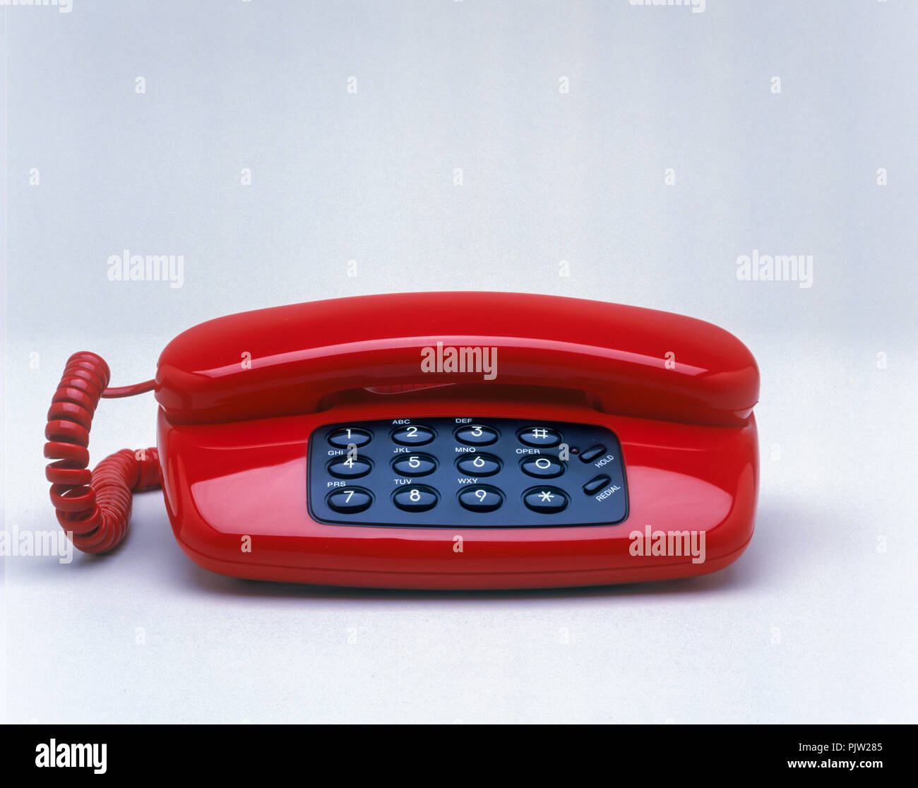 1991 HISTORICAL RED LANDLINE TELEPHONE ON WHITE BACKGROUND Stock Photo