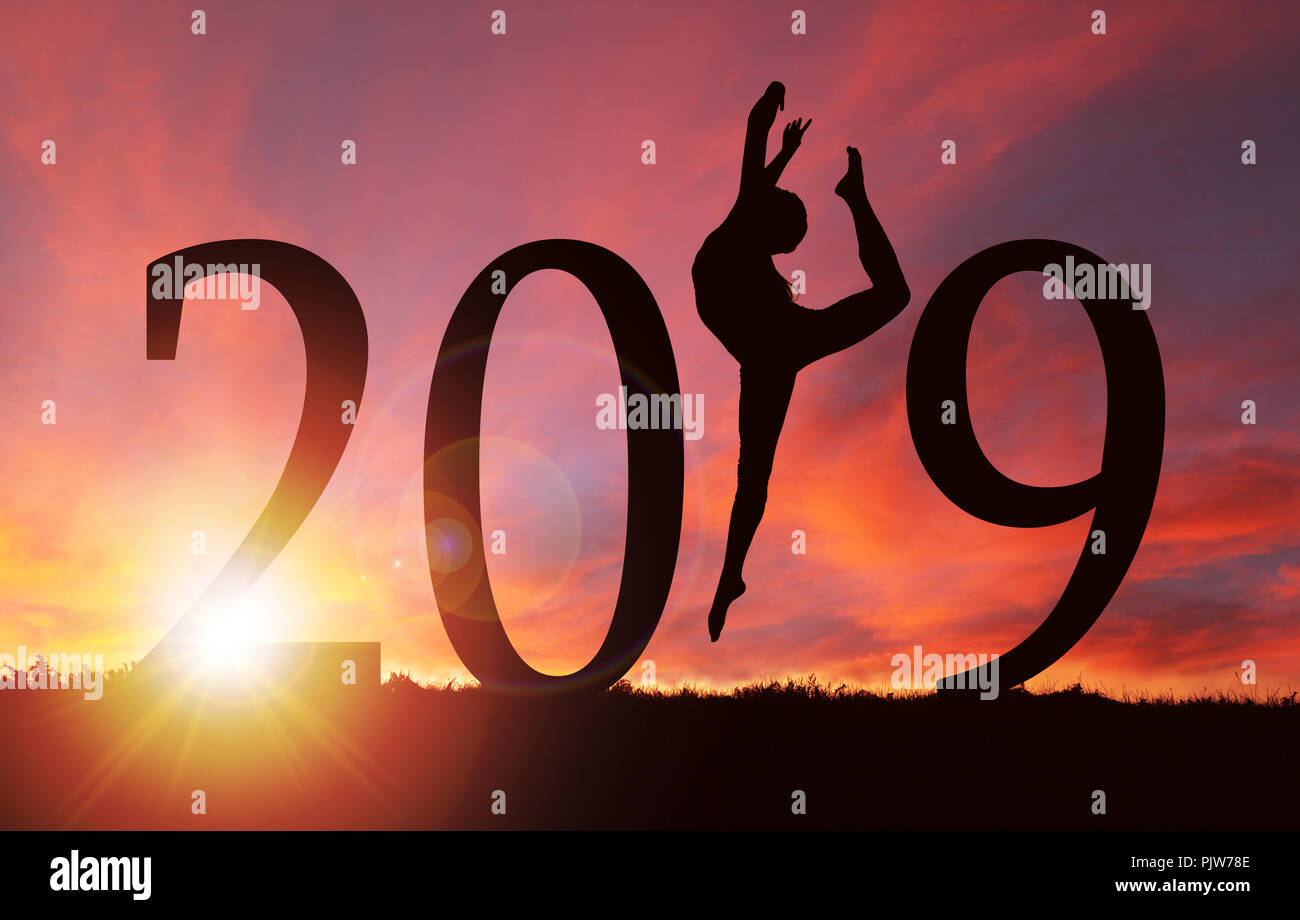 2019 New Year silhouette of a girl dancing or exercising during golden sunrise or sunset with copy space. Stock Photo