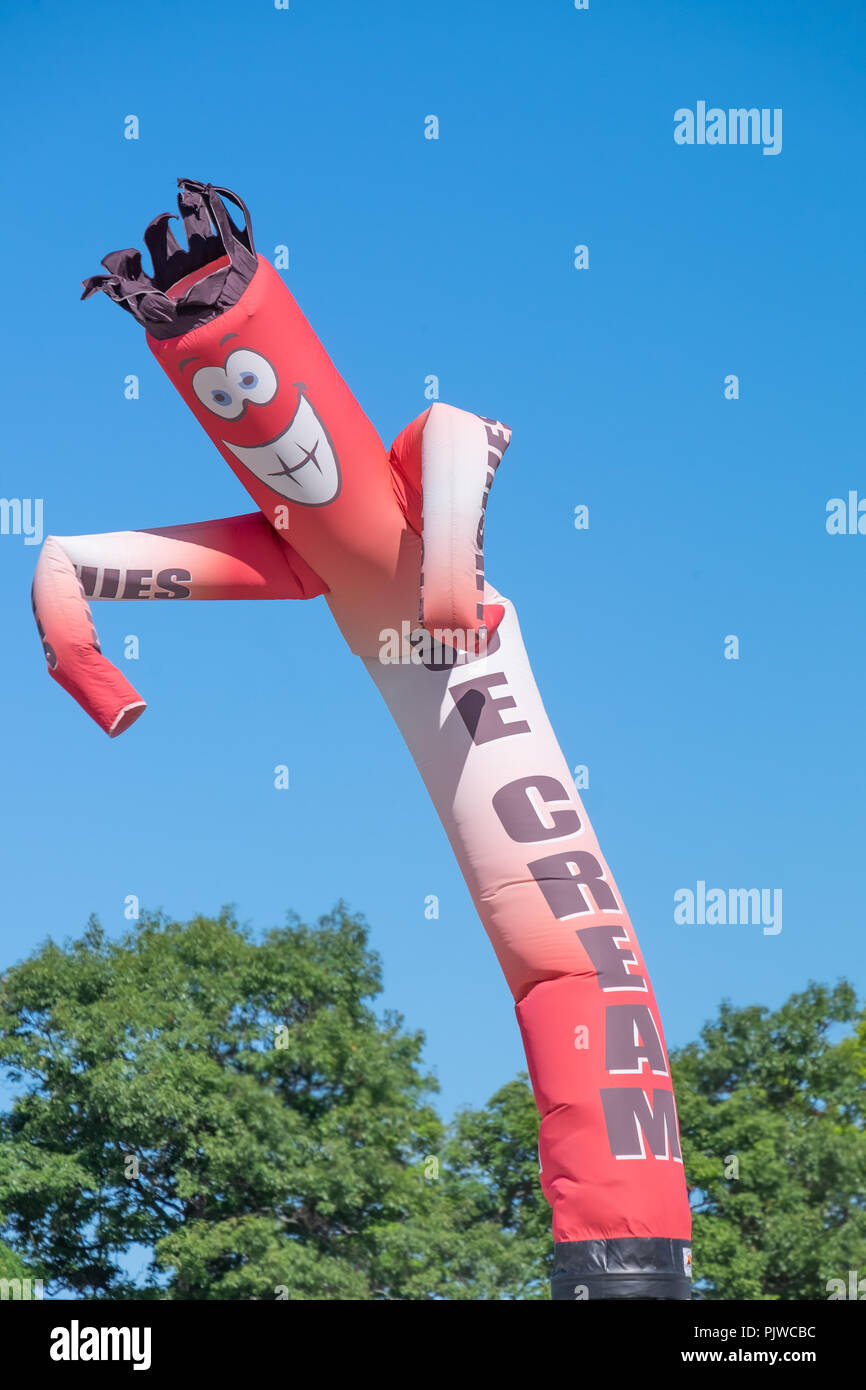 Funny inflatable sign attracts people to come to an ice cream stand at ...