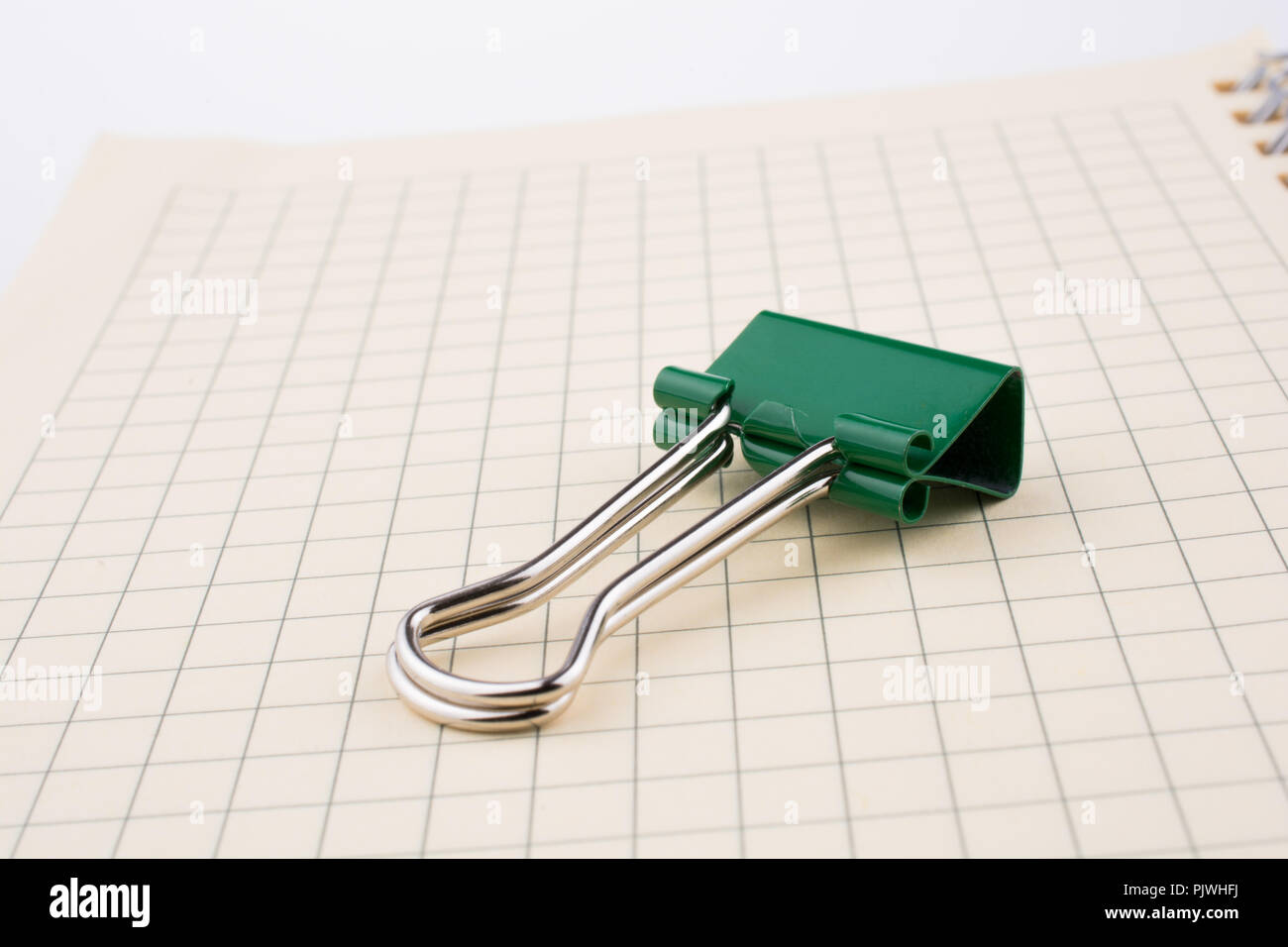 Colored paper clip on a checked notebook  page Stock Photo