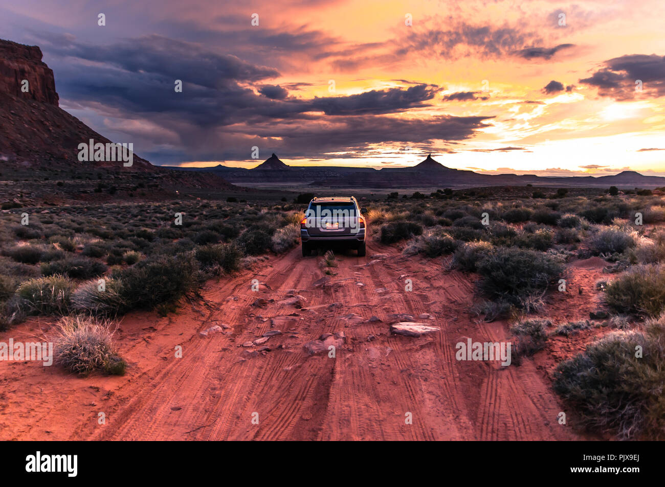 Off road vehicle facing sunset, Indian Creek, Moab, Utah, USA Stock Photo