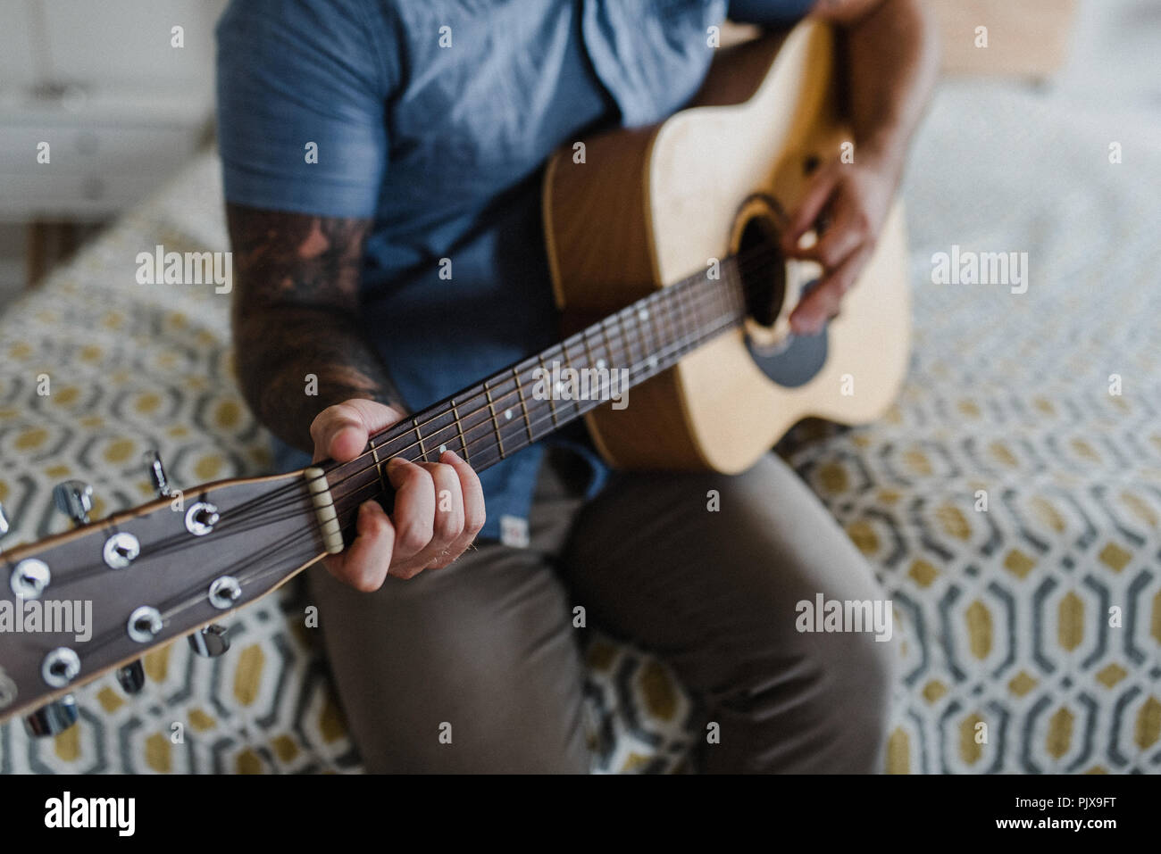 Guitarist playing music on bed Stock Photo Alamy